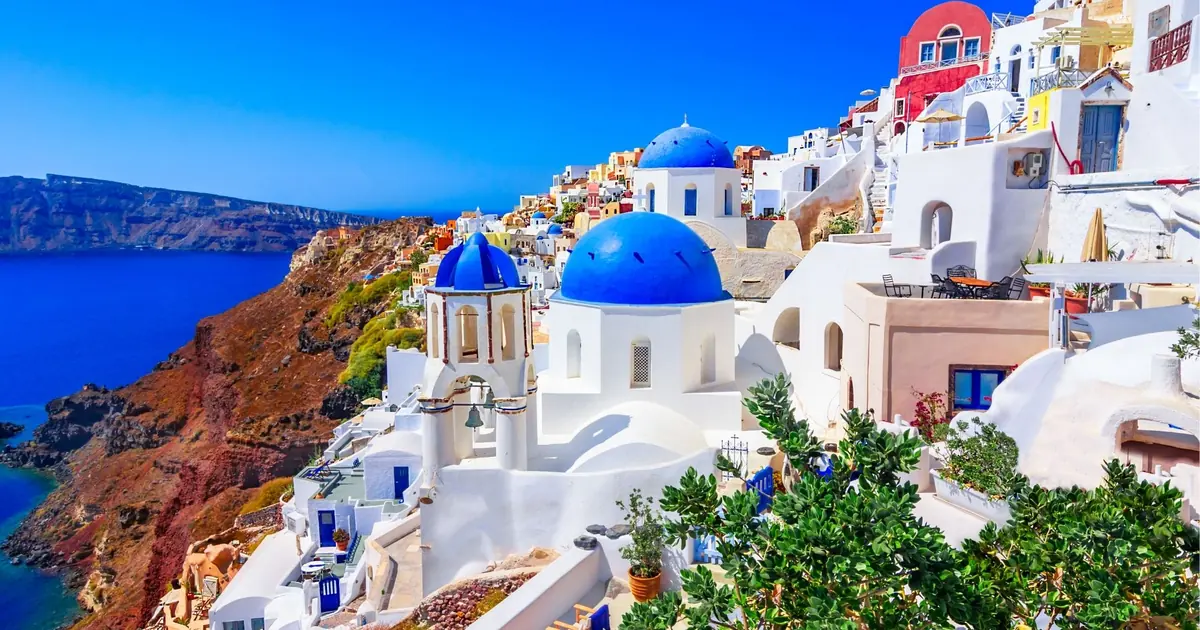 Whitewashed buildings and blue-domed churches in Oia, Santorini, above the caldera
